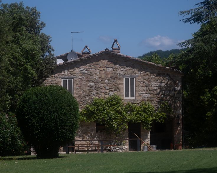 Typisches umbrisches Landhaus, umgeben von Grün und Bäumen, ideal für eine ruhige Auszeit.