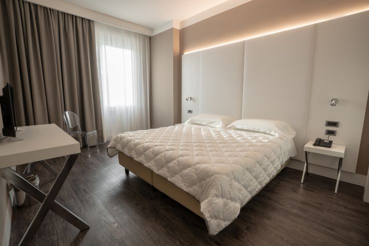 A simple and cozy room featuring comfortable beds and tidy furnishings.