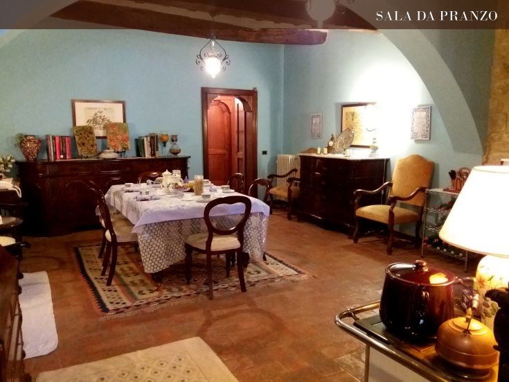 Una sala da pranzo con un tavolo sistemato per i pasti, arredato con alcuni elementi decorativi.