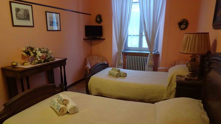 Camera semplice con letti singoli, arredamenti tradizionali e buona illuminazione naturale.