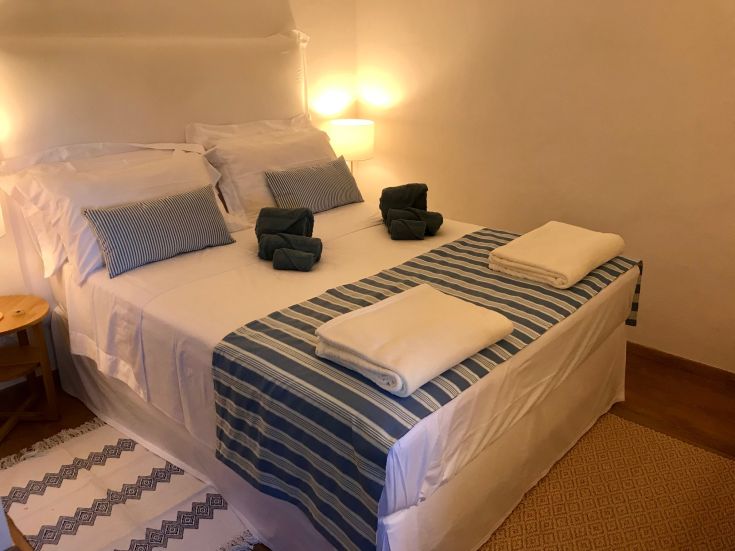 Una camera da letto semplice con biancheria bianca e dettagli blu, accogliente e funzionale.