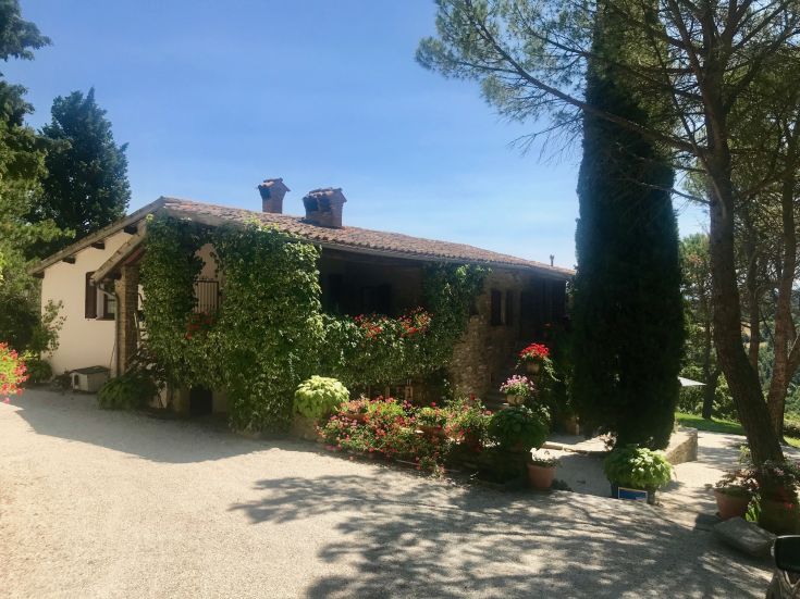 Casa accogliente circondata da un giardino verde e fiorito, perfetta per una vacanza tranquilla in Umbria.
