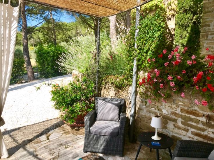 Area esterna tranquilla con sedie e piante verdi, perfetta per momenti di relax.