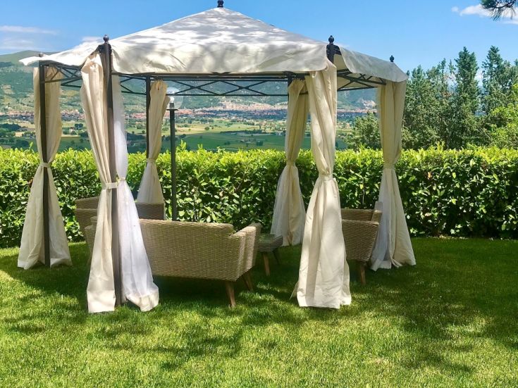 Gazebo circondato da piante, adatto per momenti di relax nel verde.
