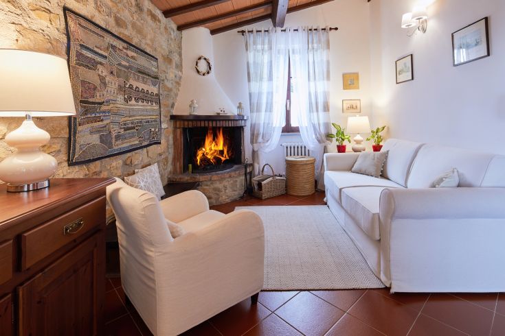 Soggiorno caldo con camino, arredato in stile semplice e rustico, perfetto per momenti di relax.