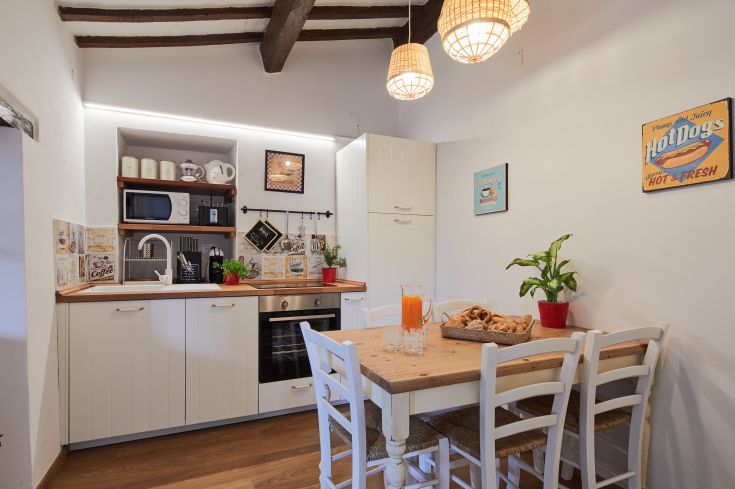 Cucina ben organizzata con arredi contemporanei, completa di stoviglie e decorazioni classiche, perfetta per socializzare.