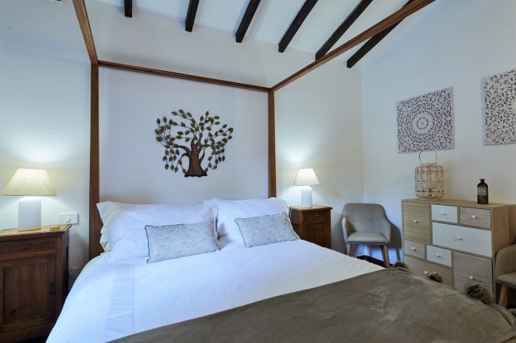 Camera semplice con letto matrimoniale e decorazioni moderate, ideale per un soggiorno tranquillo.