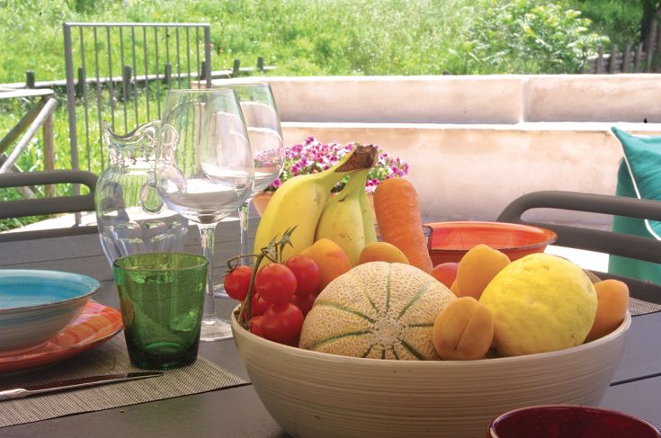 A table set with seasonal fruits and colorful dishes, perfect for an outdoor lunch with friends.
