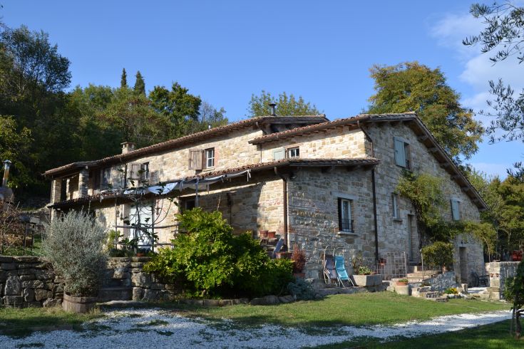 A traditional stone farmhouse located in the Chiascio valley, offering comfortable apartments and wellness activities.