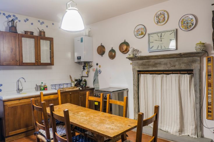 Cozy kitchen with a wooden table and rustic decorative elements.