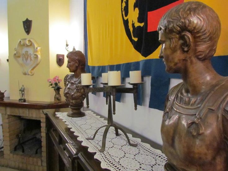 Due busti in bronzo artigianali, con candele e dettagli vintage in un ambiente rilassato.