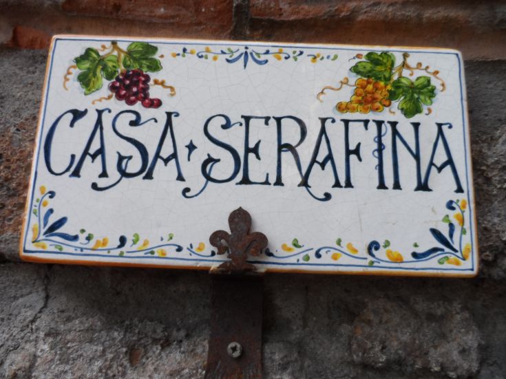 Targa di Casa Serafina, con dettagli artigianali e testo ben curato, rappresenta la tradizione locale.