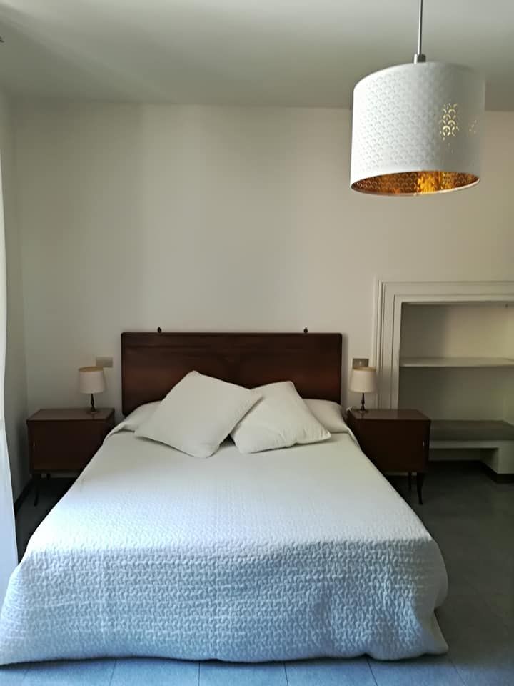 Camera semplice con letto matrimoniale e illuminazione soft, adatta per un soggiorno confortevole.