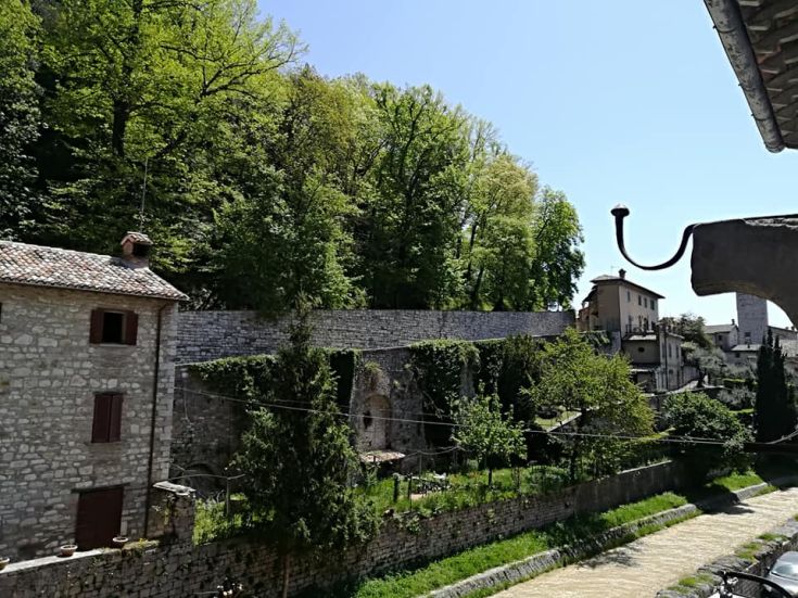 Un paesaggio naturale che presenta edifici in pietra immersi in una vegetazione verde e rigogliosa.