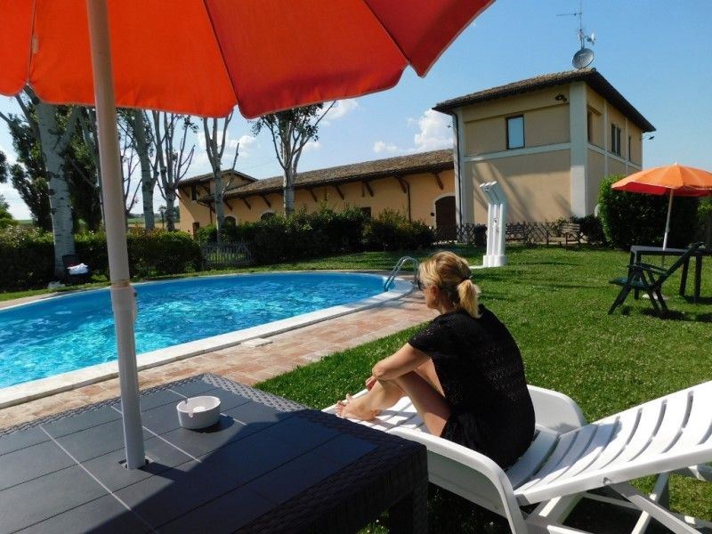 Outdoor space with a pool located in Villaggio Albergo Le Stelline, surrounded by typical Umbrian vegetation.