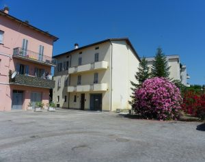 Wohngebäude umgeben von bunten Blumen und einem ruhigen Himmel.