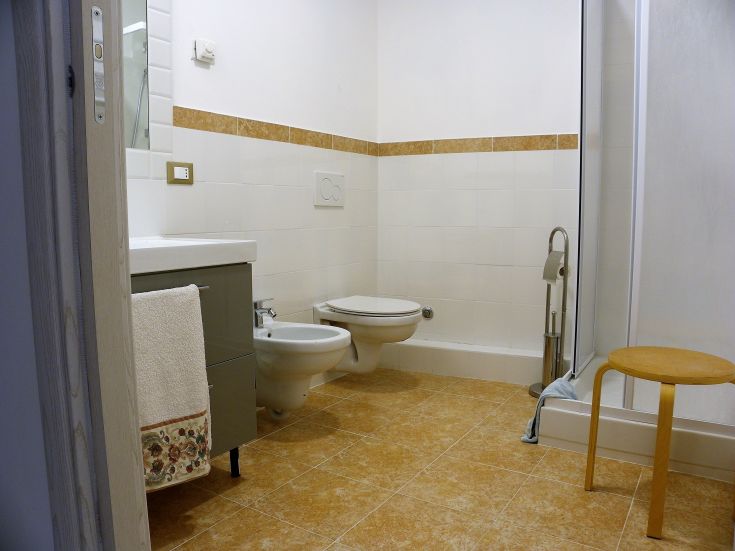 Ein heller und moderner Badezimer mit schlichten Möbeln und gefliesten Böden.