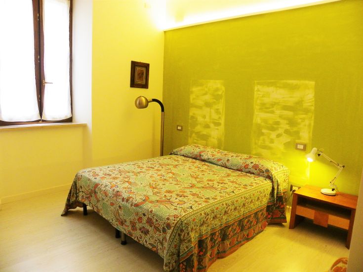 Ein gemütliches Zimmer mit einfacher Einrichtung und beruhigenden Tönen, beleuchtet von warmem Licht.