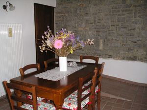 Ambiente semplice con un tavolo in legno e un mazzo di fiori freschi. Ideale per incontri informali.