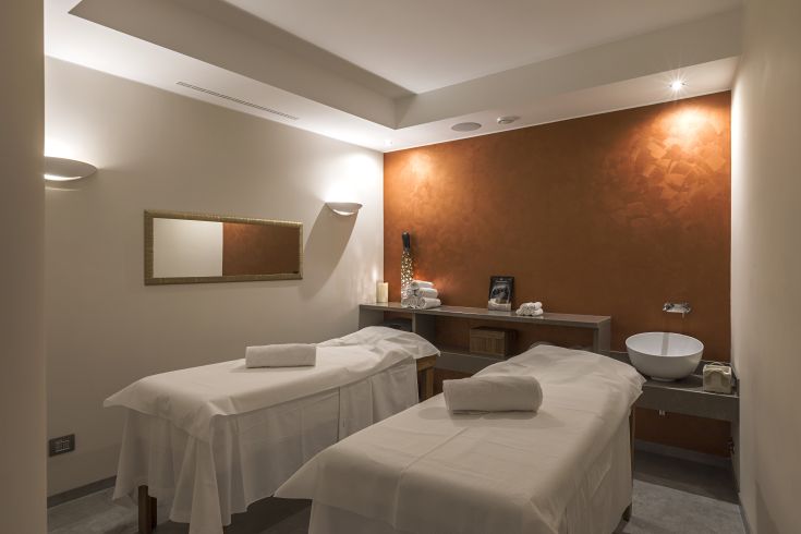 Centro benessere con lettini comodi, illuminazione soft e colori accoglienti.