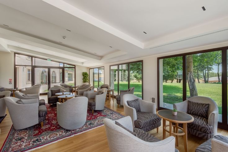 Ambiente rilassante con poltrone raffinate e panorama sulla natura circostante.