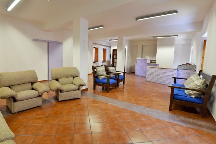 Hostel Park's lounge, featuring simple chairs and a fully equipped kitchen.