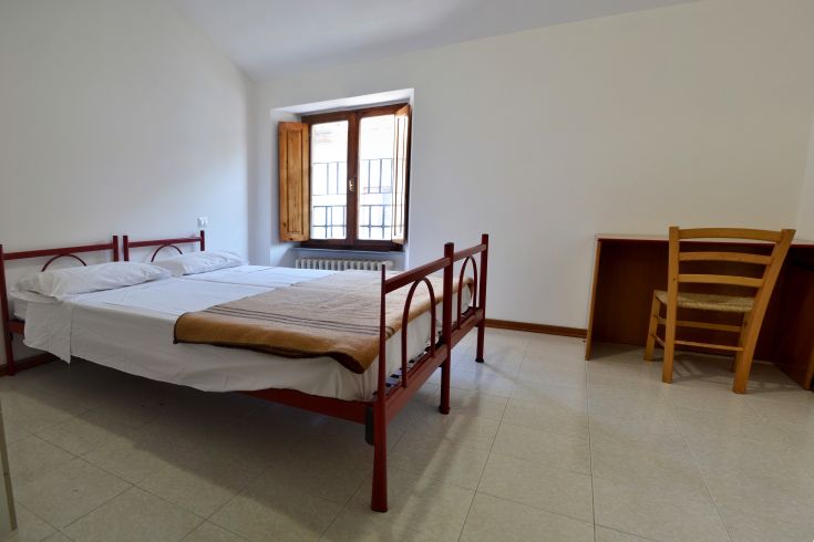 Bright room with single beds and a window offering a scenic view. Cozy space for relaxation.