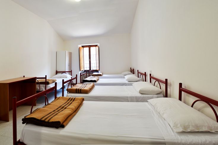 Room with single beds and minimal decor, perfect for a functional and relaxed stay.