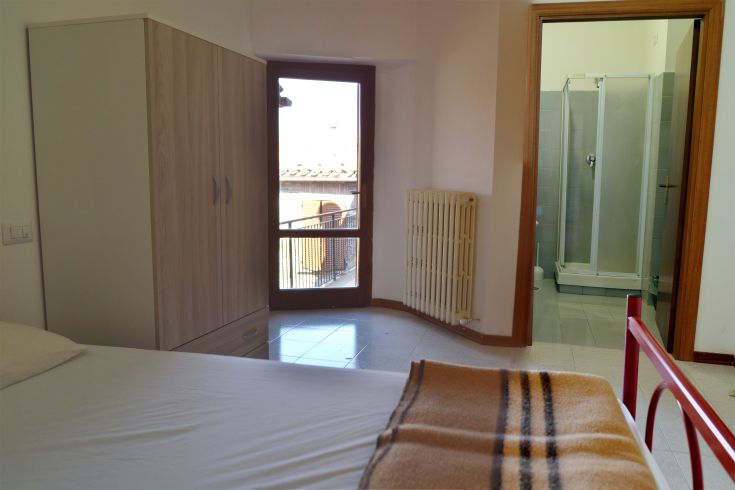Simple room with a wardrobe and private bathroom, perfect for a stay in Umbria.