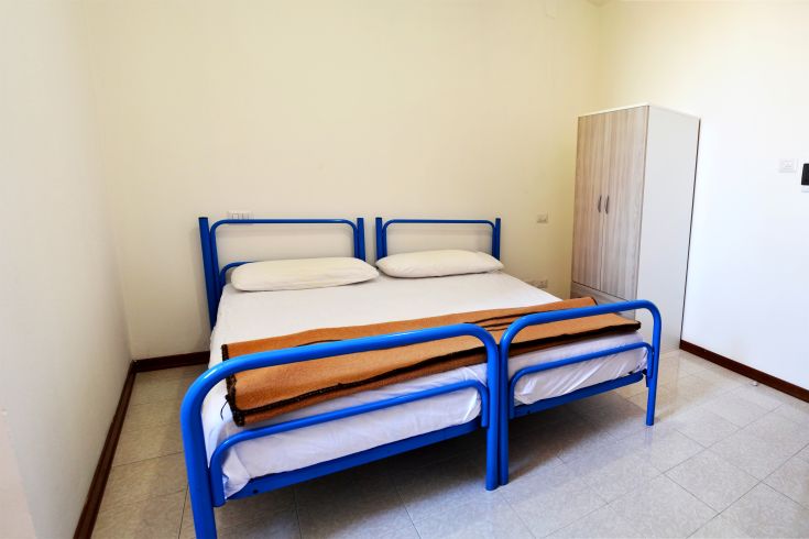 Comfortable room with a double bed and wardrobe, located in a relaxed and bright environment.