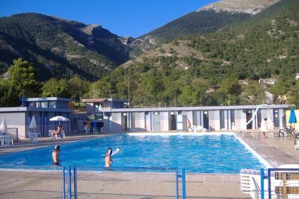 A natural pool surrounded by a lush environment, with greenery and hills in the distance, ideal for relaxation.