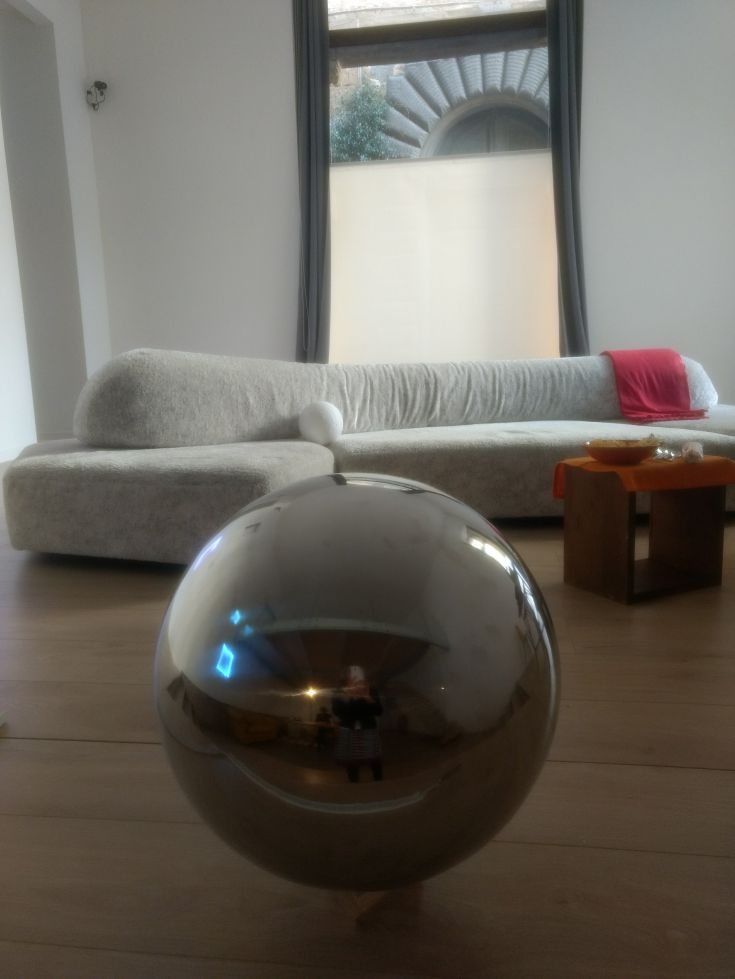 Un loft moderno caratterizzato da un design semplice e funzionale, con arredi curati. Una palla riflettente arricchisce l'ambiente.