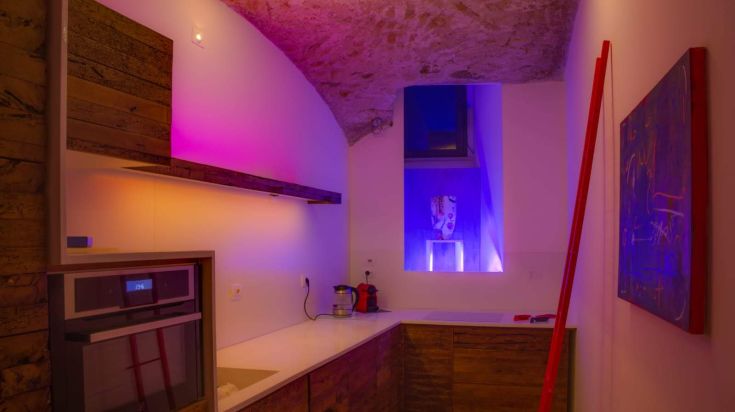 Cucina di un loft caratterizzata da design moderno, illuminazione soft e materiali semplici.