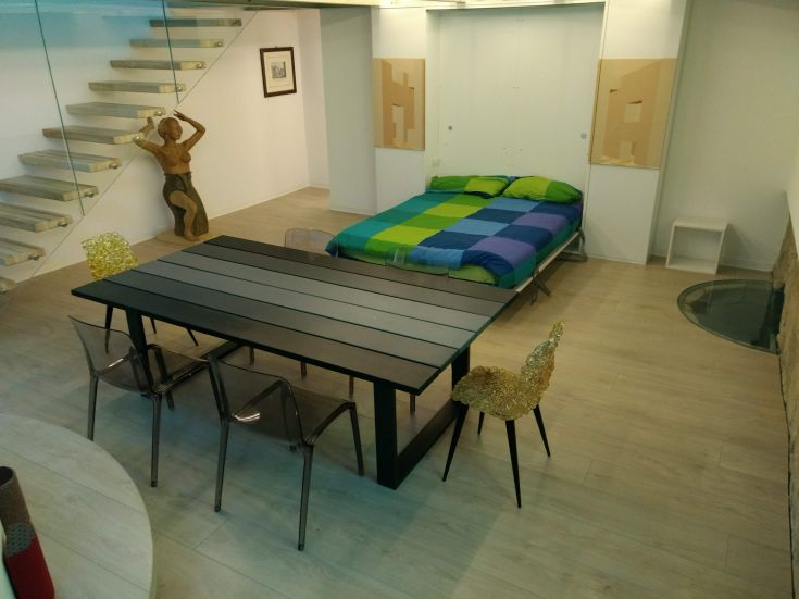 Un loft moderno e luminoso con arredi semplici e funzionali, ideale per momenti di relax.