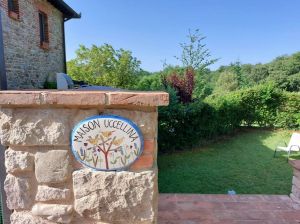 Un edificio umbro circondato da un giardino e una piscina, ideale per famiglie.