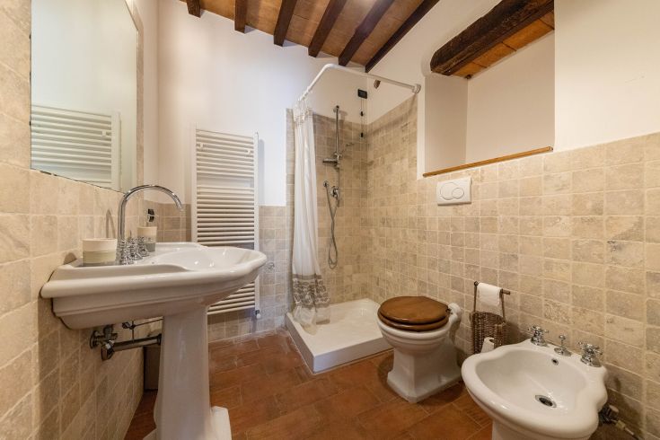 Un bagno moderno con pareti piastrellate in tonalità chiare e dettagli in legno decorativo.