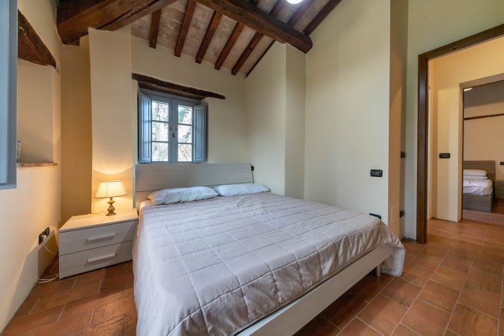 Spazio accogliente con letto matrimoniale in un palazzo umbro, ideale per famiglie.