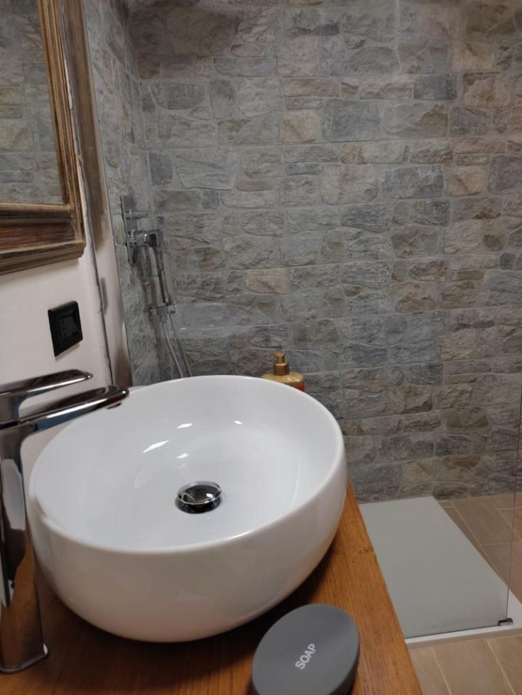 A simple bathroom with a modern sink and stone wall, perfect for moments of tranquility.