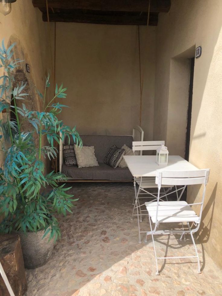 A comfortable and well-lit relaxation area with a sofa and a table, enhanced by green plants.