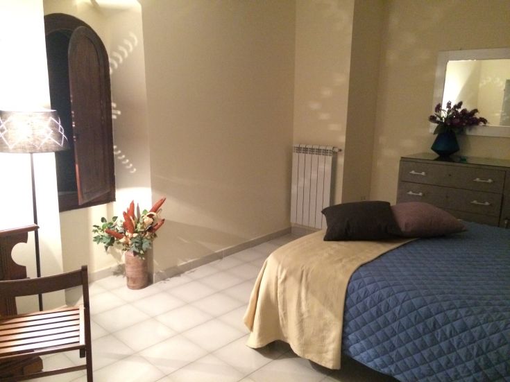 Simple, bright room featuring a double bed, functional furniture, and a relaxing atmosphere.