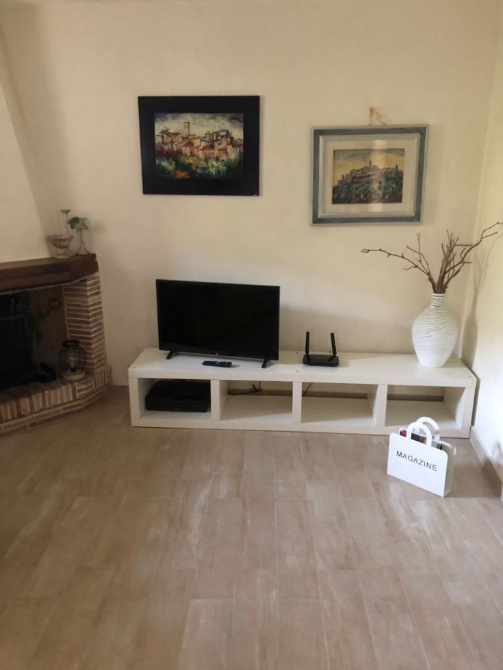 A cozy living room with a TV and simple details, perfect for relaxation moments.