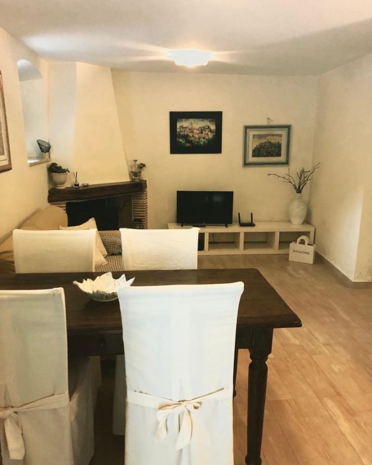 Spacious and well-lit interior of a home, featuring a table, sofa, and living area equipment.