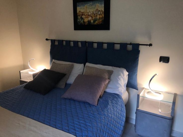 Interior of a simple bedroom with lit, removable lamps. Relaxing and welcoming atmosphere.