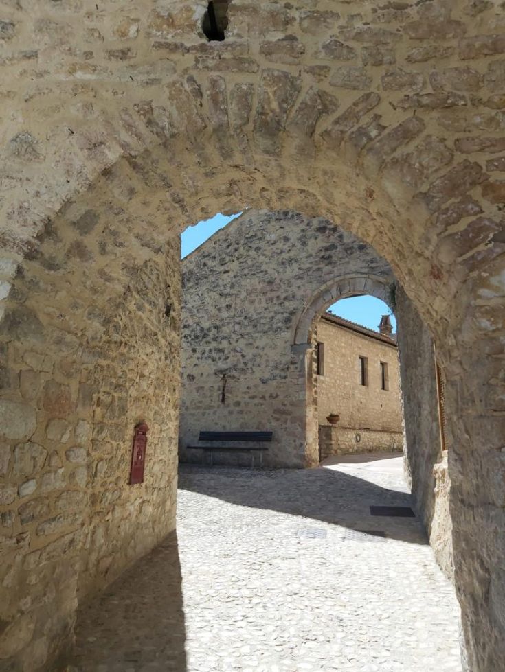 A serene stone alley in an ancient village, featuring historic buildings and a peaceful atmosphere.