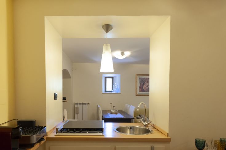 A simple kitchen with a well-lit dining area, creating a family-friendly atmosphere.