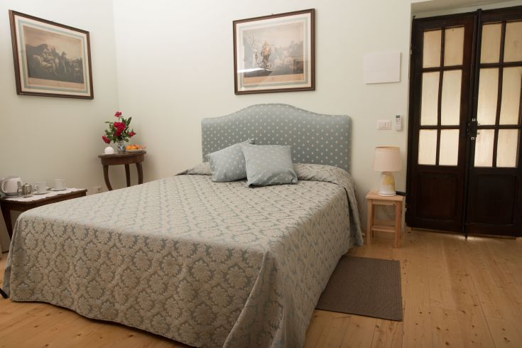 Simple and cozy bedroom with a double bed and some decorative elements.