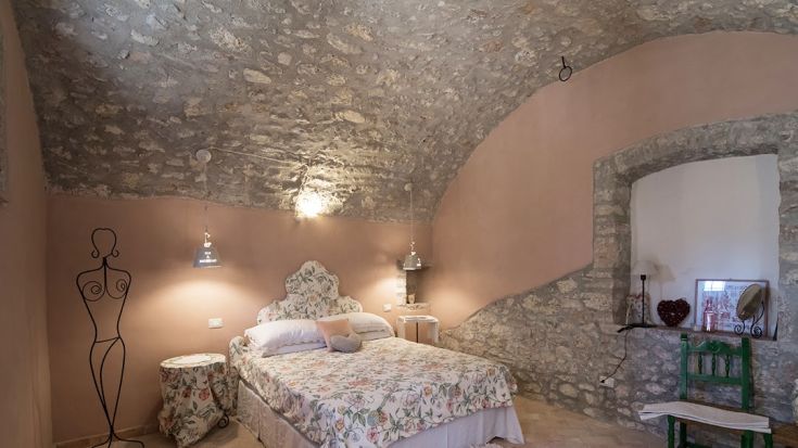 Simple bedroom with a vaulted ceiling and a few decorative elements.