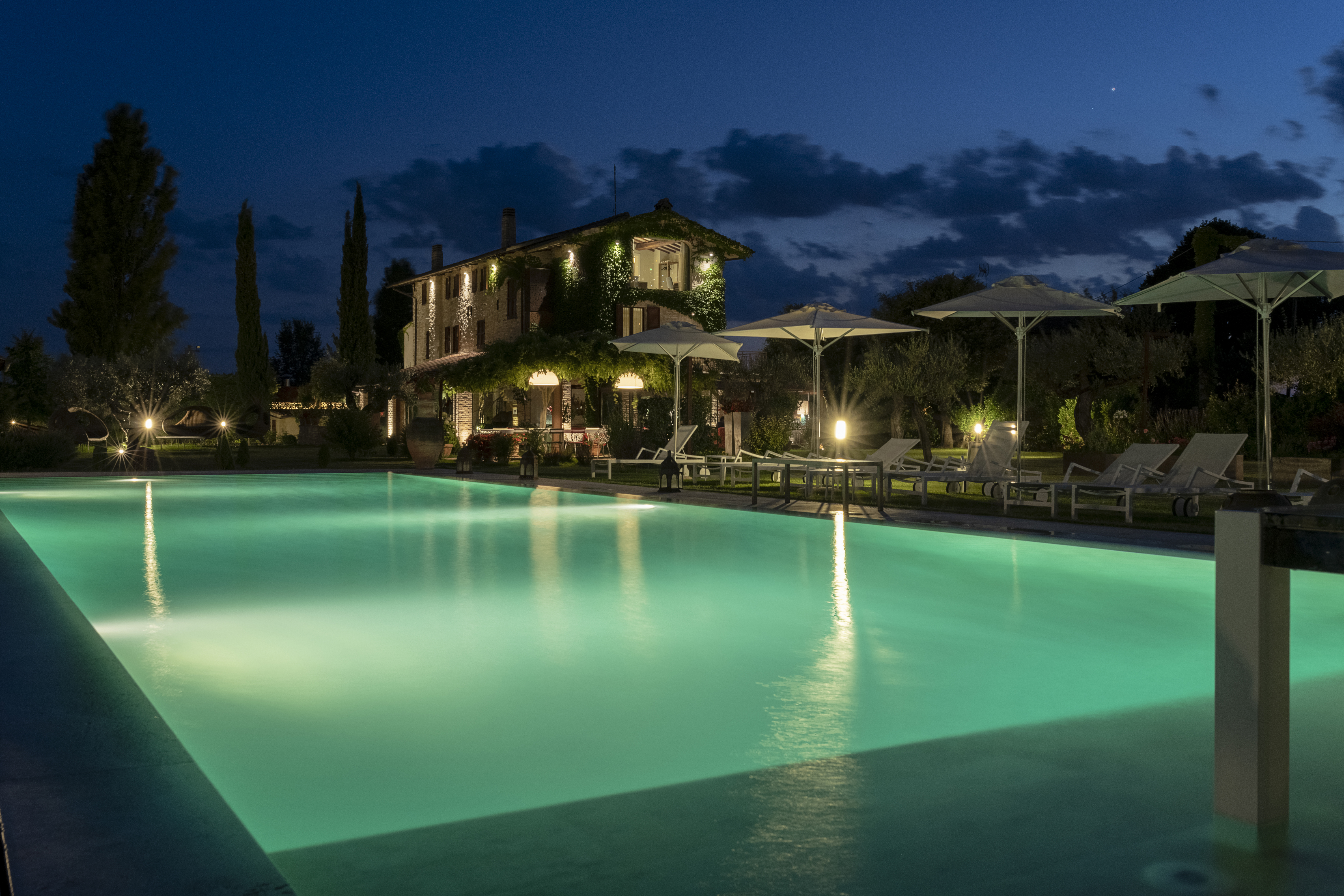 Una villa con piscina illuminata crea un'atmosfera tranquilla e accogliente nella serata estiva.