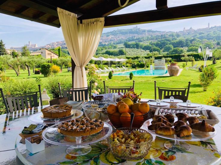 Colazione abbondante nel giardino, circondati da un verde lussureggiante.