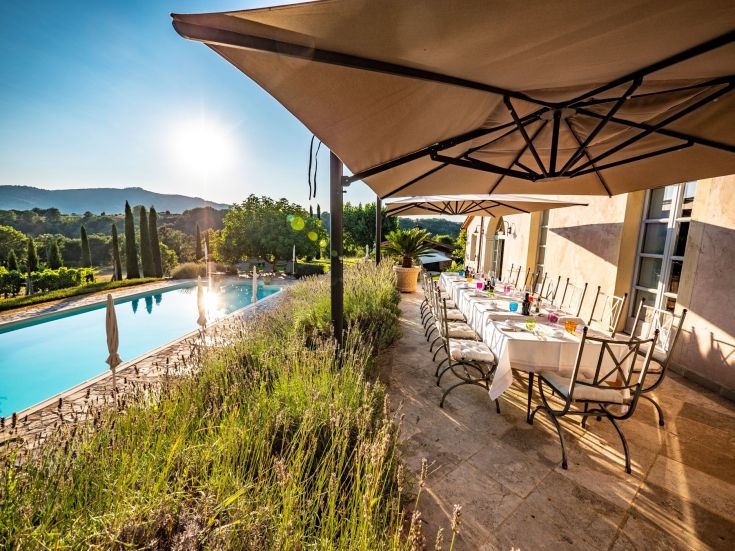 Un'area esterna con piscina e tavolo apparecchiato, circondata dalla natura.